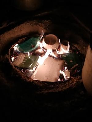 Dépot des pièces raku dans les copeaux de bois pour enfumer les pièces