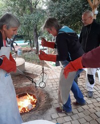 Stage raku : sortie des pièces du four et dépôt sur des copeaux de bois pour être enfumées